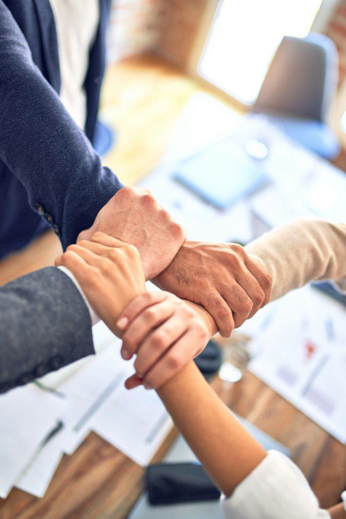 Coworkers stacking their hands together over a desk