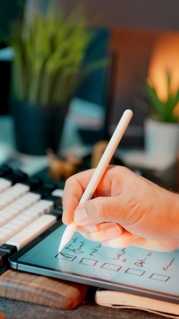 Person writing notes with a pen at a desk
