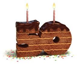 Chocolate layer cake shaped like the number 50 with lit candles